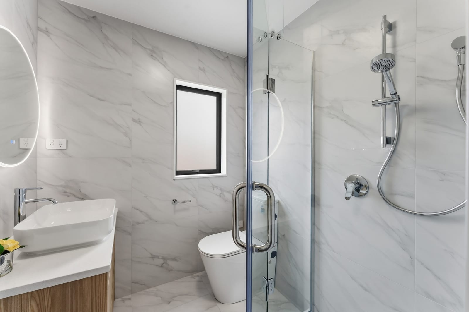Tiled bathroom with a glass shower and a vessel basin