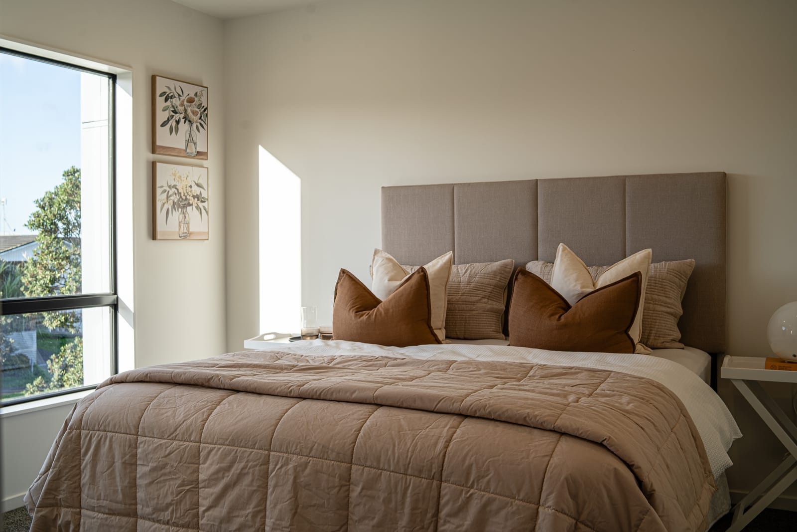 Bedroom with an upholstered headboard in warm afternoon light