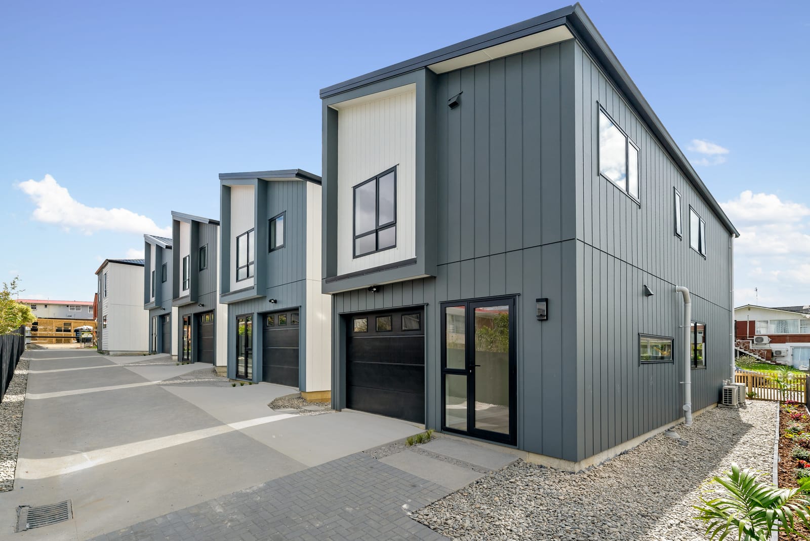 The shared driveway by day, lined with the garages of the homes