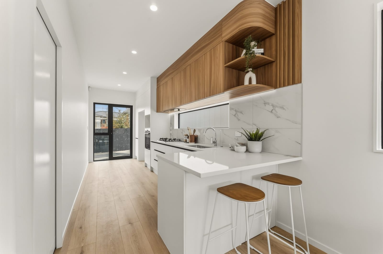 Kitchen with timber-lined cabinetry, a breakfast bar and a window splashback