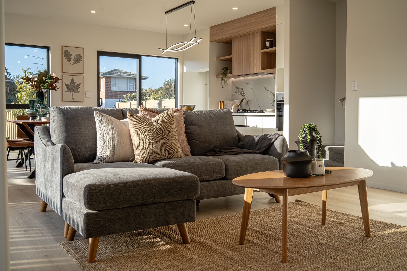 Lounge with a chaise sofa, with the kitchen and dining area behind