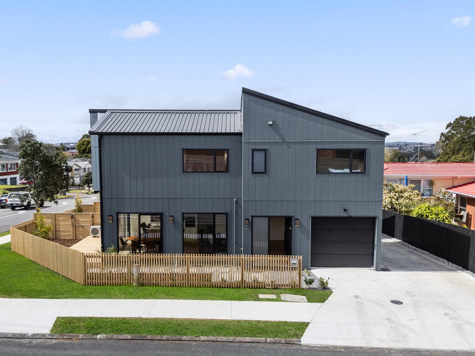 Lot 1 by day on the corner, with its fenced garden, garage and new concrete driveway